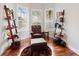 Cozy sitting area with tufted chair, ottoman, wood floors, and shelving at 2515 Ridgewind Way, Windermere, FL 34786