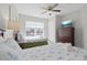 Bright bedroom features two beds, a ceiling fan, a dresser, and a window providing ample natural light at 2604 Lodi Cir # 103, Kissimmee, FL 34746