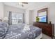 Bright bedroom with a ceiling fan, large window and a mounted television on a dresser at 2604 Lodi Cir # 103, Kissimmee, FL 34746