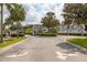 Road leading to community entrance featuring lush landscaping and architecture at 2604 Lodi Cir # 103, Kissimmee, FL 34746