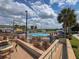 Inviting community pool with plenty of seating, palm trees, and lake views at 2604 Lodi Cir # 103, Kissimmee, FL 34746