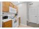 Compact kitchen design with essential appliances, wooden cabinets, and stairs nearby at 2604 Lodi Cir # 103, Kissimmee, FL 34746