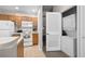 Kitchen featuring a white refrigerator, stove, microwave and access to the washer and dryer at 2604 Lodi Cir # 103, Kissimmee, FL 34746