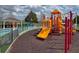 Community playground featuring bright slides and play equipment in a safe, mulched play area at 2604 Lodi Cir # 103, Kissimmee, FL 34746