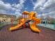 Community playground featuring a large slide, climbing structures, and a soft landing surface at 2604 Lodi Cir # 103, Kissimmee, FL 34746