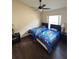 Bright bedroom featuring dark wood floors, two twin beds with themed bedding, and a ceiling fan at 2678 Autumn Creek Cir, Kissimmee, FL 34747