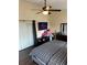 Bedroom with dark wood floors, a ceiling fan, large windows, and a dresser for plenty of storage at 2678 Autumn Creek Cir, Kissimmee, FL 34747