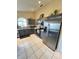 Modern kitchen featuring gray cabinets, stainless steel appliances, and ample counter space with an arched window at 2678 Autumn Creek Cir, Kissimmee, FL 34747
