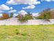 Backyard with a white fence under a sunny blue sky with fluffy clouds at 2776 Tropical Lake Dr, Kissimmee, FL 34741