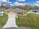 Aerial view of single-story home featuring a front yard, driveway, and attached garage at 2776 Tropical Lake Dr, Kissimmee, FL 34741