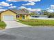 Charming yellow home featuring a one-car garage and arched entryway at 2776 Tropical Lake Dr, Kissimmee, FL 34741