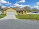 A sunny yellow home with a single-car garage and an arched front entryway at 2776 Tropical Lake Dr, Kissimmee, FL 34741
