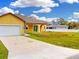 Single-story home featuring a front yard, driveway, and attached garage at 2776 Tropical Lake Dr, Kissimmee, FL 34741