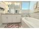 Bathroom with dual sink vanity, framed mirror, and soaking tub featuring decorative accents at 2909 Theme St, Kissimmee, FL 34746