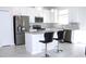 Bright kitchen boasts stainless appliances, gray countertops, island with seating and white cabinets at 2909 Theme St, Kissimmee, FL 34746
