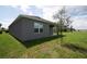Exterior of home with grassy backyard and young tree at 30376 Armenia Rd, Leesburg, FL 34748