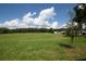 Large grassy backyard with distant trees and clear blue sky at 30376 Armenia Rd, Leesburg, FL 34748