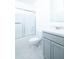 A bathroom featuring a shower-tub combination and single sink vanity with gray cabinets at 30376 Armenia Rd, Leesburg, FL 34748