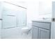 A bathroom featuring a shower-tub combination and single sink vanity with gray cabinets at 30376 Armenia Rd, Leesburg, FL 34748