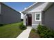 Charming front entry with a covered porch and red front door, complemented by lush green landscaping at 30376 Armenia Rd, Leesburg, FL 34748