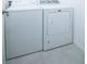 Modern laundry room showcasing a white washer and dryer set with tile flooring at 30376 Armenia Rd, Leesburg, FL 34748