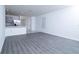 Spacious living area featuring gray wood-look floors and a view into the bright, open kitchen with stainless appliances at 30376 Armenia Rd, Leesburg, FL 34748