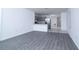 Open-concept living room with gray wood-look floors connected to a modern kitchen with stainless steel appliances at 30376 Armenia Rd, Leesburg, FL 34748