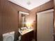 Bathroom features striped wallpaper, a wood vanity, and a separate room with a toilet at 3725 Blossom St, Kissimmee, FL 34746