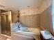 Well-lit bathroom featuring a soaking tub, tiled walls and a separate glass shower at 3725 Blossom St, Kissimmee, FL 34746