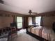 Bedroom with a ceiling fan, two windows, and a bed with a colorful comforter at 3725 Blossom St, Kissimmee, FL 34746