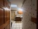 Hallway shot to laundry room, with skylight, cabinets, sink and washer, with patterned wall paper at 3725 Blossom St, Kissimmee, FL 34746
