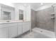 Modern bathroom with double vanity, stone tile, and walk-in shower at 381 Singing Sands Cir, Lake Wales, FL 33859