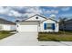 Charming single-Gathering home with a two-car garage, neat landscaping, and vibrant blue shutters at 381 Singing Sands Cir, Lake Wales, FL 33859