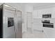 Modern kitchen with stainless steel refrigerator, white cabinets, and pantry for storage at 381 Singing Sands Cir, Lake Wales, FL 33859