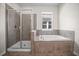 Bathroom featuring tile surround tub with shower and a glass door at 3848 Cabo Rojo Dr, St Cloud, FL 34772