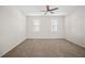 Spacious carpeted bedroom features a modern ceiling fan and sunlit windows with modern blinds at 3848 Cabo Rojo Dr, St Cloud, FL 34772