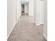 Long hallway with neutral tile floors and white trim leading to various rooms in the home at 3848 Cabo Rojo Dr, St Cloud, FL 34772