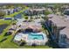 Aerial view of community pool with clubhouse, spa, lounge seating and parking spaces at 4105 Tropical Isle Blvd # 222, Kissimmee, FL 34741