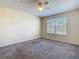 Bright bedroom features carpet, a ceiling fan, and a window letting in natural light at 4105 Tropical Isle Blvd # 222, Kissimmee, FL 34741