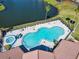 Aerial view of community pool featuring a spa and lounge seating with water views at 4105 Tropical Isle Blvd # 222, Kissimmee, FL 34741
