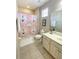 Bathroom with a blue nautical themed shower curtain, vanity with sink and a window at 4441 Shiva Loop, Kissimmee, FL 34746