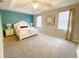 Spacious bedroom with a tray ceiling, a large bed, a ceiling fan and large windows at 4441 Shiva Loop, Kissimmee, FL 34746