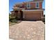Inviting two-story home featuring a tile roof, arched entry, and paver driveway at 4441 Shiva Loop, Kissimmee, FL 34746