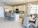 Spacious open-plan kitchen with breakfast bar, stainless steel appliances, and dining area at 4441 Shiva Loop, Kissimmee, FL 34746
