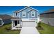 Charming two-story home featuring a covered entry, two-car garage, and beautifully landscaped front yard at 606 Bell Prairie Cir, Lake Wales, FL 33859