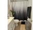 Well-lit bathroom featuring a toilet, sink and vanity, decorative shower curtain, and tiled floors at 633 Kangaroo Dr, Kissimmee, FL 34759
