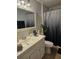 Bathroom with a white vanity, framed mirror and a shower with a decorative curtain at 633 Kangaroo Dr, Kissimmee, FL 34759