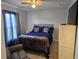 Well-lit bedroom features a bed with nightstands and a TV atop a white chest of drawers at 633 Kangaroo Dr, Kissimmee, FL 34759