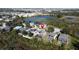 Aerial view showcases houses with screened patios and a lake, in a residential community with a red pin marking a property at 802 Suffolk Pl, Davenport, FL 33896