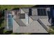 Aerial view of a home featuring a screen enclosed pool and spa, as well as solar panels on the roof at 802 Suffolk Pl, Davenport, FL 33896